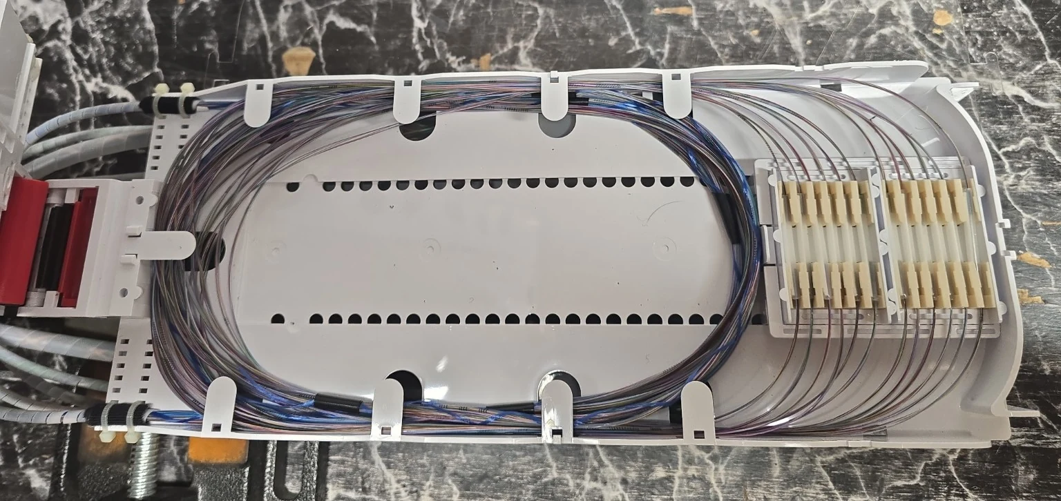 Fiber optic splice tray with organized fiber routing and fusion splices completed by Obsidian Broadband.